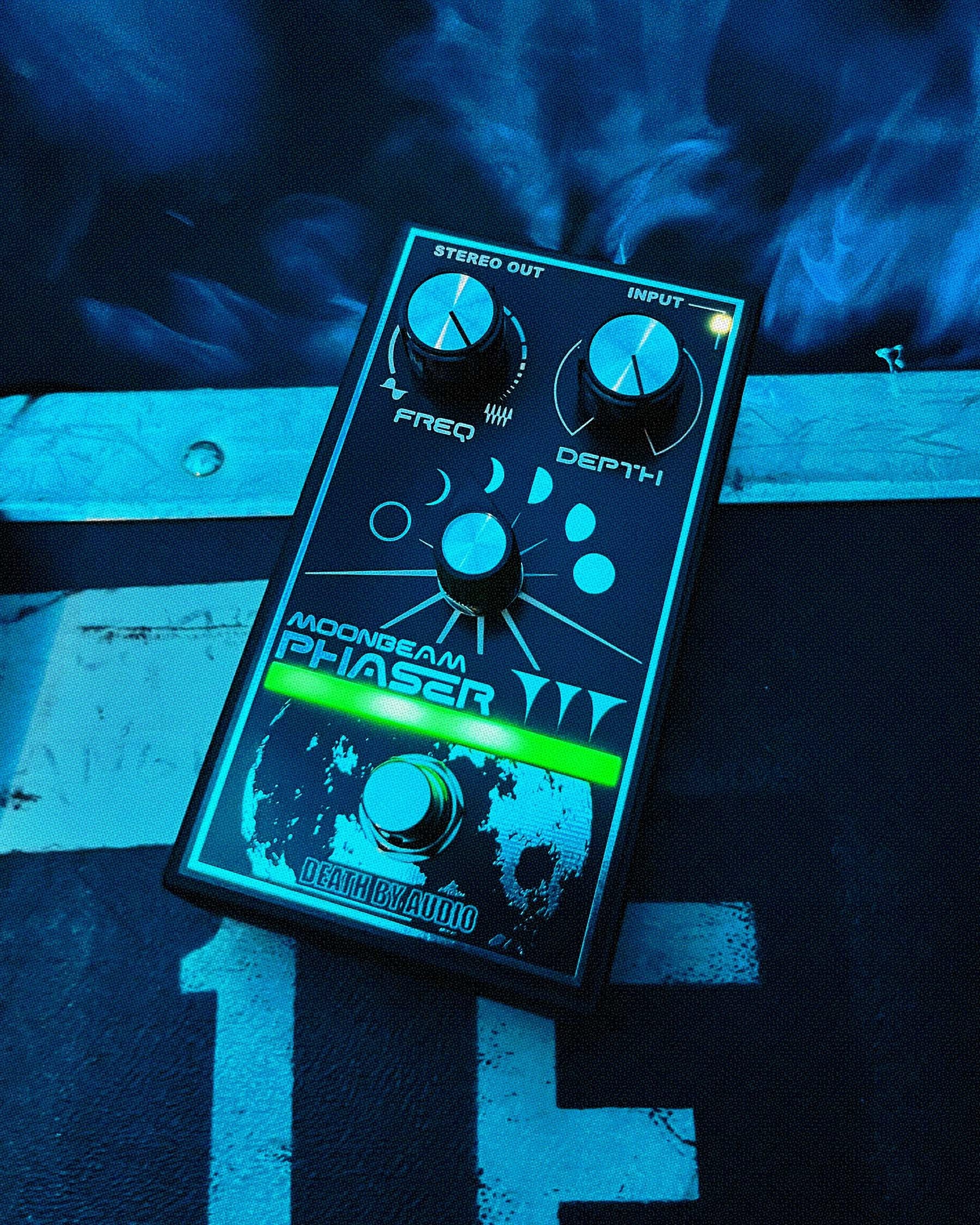 Death by Audio Moonbeam Phaser on a weathered plank in blue haze with the stage indicator glowing green
