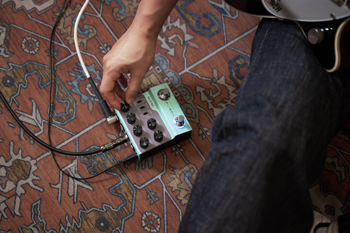 Valeton VDS-1D Digital Delay & Reverb Pedal — guitarist adjusting the pedal on the floor