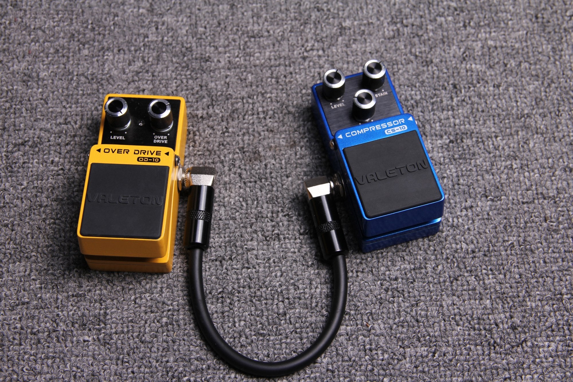 Valeton VPC-1 patch cable connecting an orange overdrive pedal to a blue compressor pedal