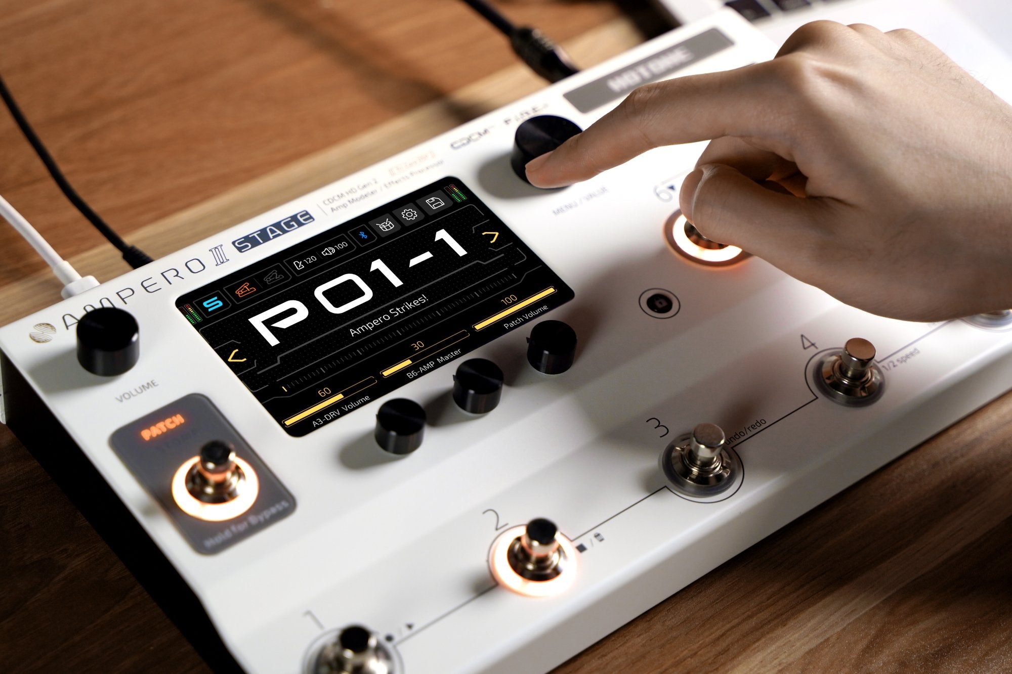 Hand tapping the touchscreen of the Hotone Ampero II Stage amp modeler