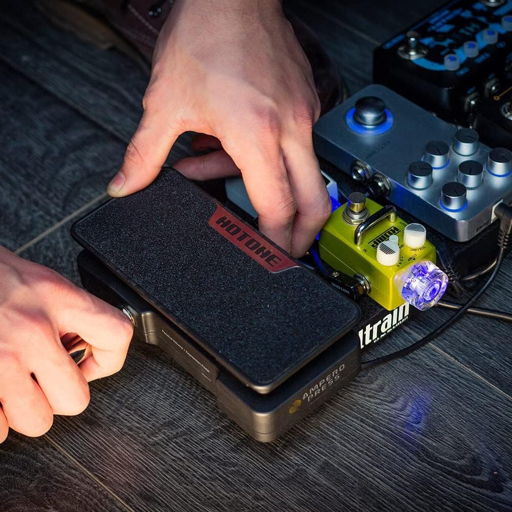 Hand operating the Hotone Ampero Press SP-30H rocker pedal on a pedalboard