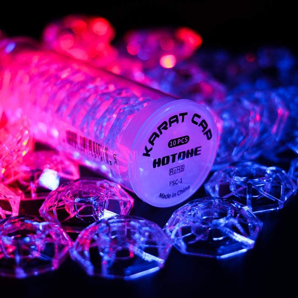 Hotone Karat Cap packaging tube surrounded by clear faceted footswitch covers under colored lighting