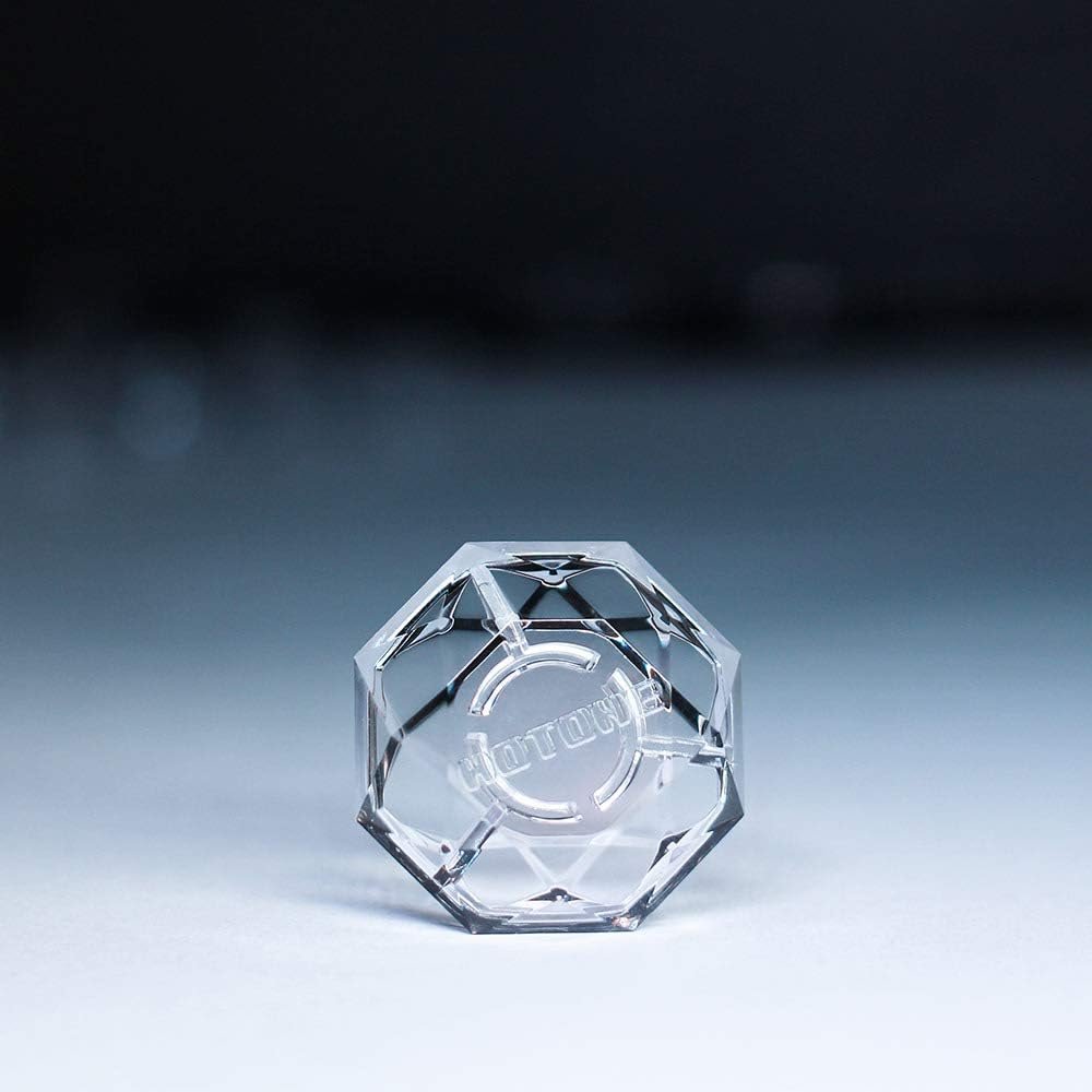 Close-up of a single clear faceted Hotone Karat Cap footswitch cover